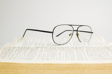 Glasses on open book with white background