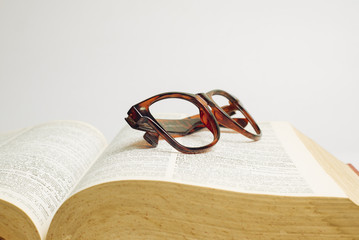 Glasses on open book with white background