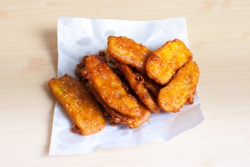 Banana fried on paper with wooden background color