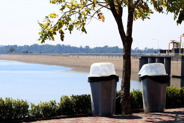 Naklejka premium Junk, Bin, Garbage, Plastic waste bin clear trash sideways walk at riverside, Waste plastic bin on floor