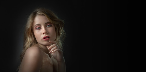 Naklejka premium Beautiful sexy blonde on a black background .