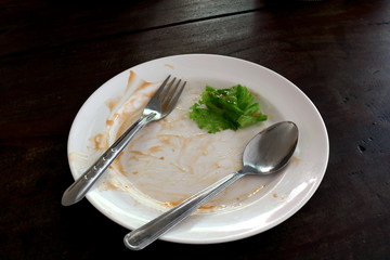 plate empty trash food and Leaves of green vegetables on a plate of rice, plate fork and spoon