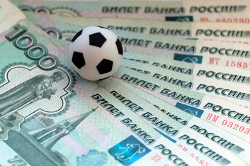 The soccer ball lies on Russian banknotes with a face value of one thousand rubles. How much is the World Cup, what salary do players have Corruption, bribes or bets in sports.