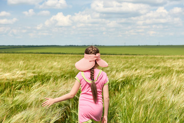 child walking through the wheat field, bright sun, beautiful summer landscape