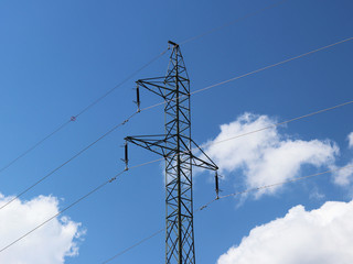 A high-voltage power line illuminated by sunlight against a background of clouds of a stormy sky. Transport of energy over long distances. High technology of modernity.Power industry. Ecology.