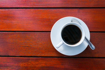 A cups of coffee on orange color wooden table background