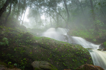 Waterfall landscape view of fresh water flows over a vertical drop to green field in Tropicana