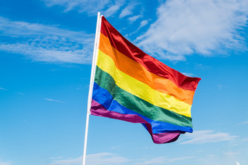 pride flag on a blue cloudy sky