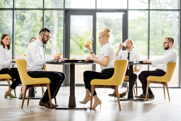 Business people having lunch with delicious meals sitting in pairs at the modern restaurant