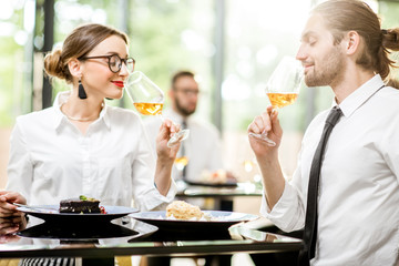 Beautiful couple enjoying wine sitting during a business lunch at the bright restaurant