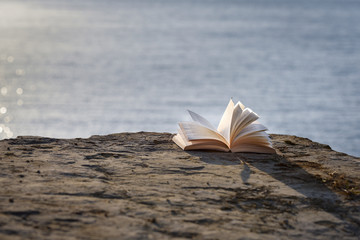 Open book at beach. Reading on a summer vacation