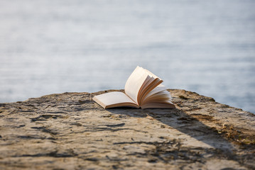Open book at beach. Reading on a summer vacation