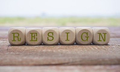 Resign word written on cube shape wooden blocks on wooden table.