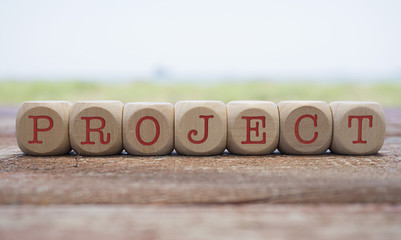 Project word written on cube shape wooden blocks on wooden table.