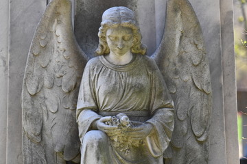 Sculpture of an angel who holds flowers in his hand