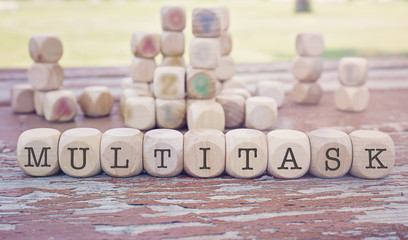 Multitask word written on cube shape wooden blocks on wooden table.