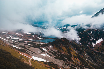 Beautiful mountain landscape, two large lakes surrounded by mountains covered with snow in fog