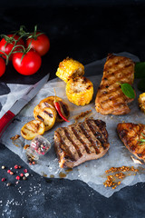 Three types of grilled meats with vegetables and spices on paper