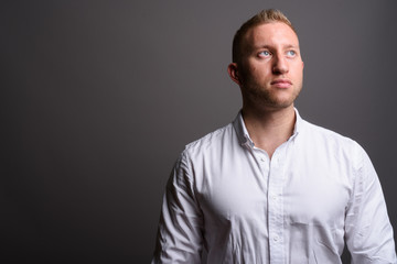 Businessman with blond hair against gray background