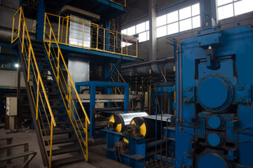 Manufacture of galvanized steel by rolling. Galvanized steel passes through coils. Roll of galvanized steel or metal on machine in industrial workshop on rolling mill, manufacturing metalwork factory