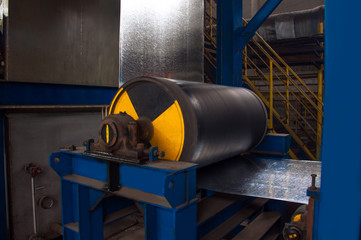 Manufacture of galvanized steel by rolling. Galvanized steel passes through coils. Roll of galvanized steel or metal on machine in industrial workshop on rolling mill, manufacturing metalwork factory