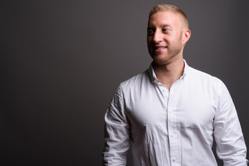 Businessman with blond hair against gray background