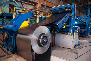 Manufacture of galvanized steel by rolling. Galvanized steel passes through coils. Roll of galvanized steel or metal on machine in industrial workshop on rolling mill, manufacturing metalwork factory 