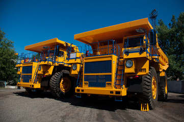 Two new quarry dump trucks on the industrial site of the workshop