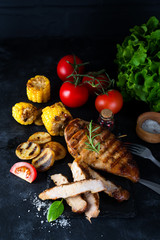 Grilled steak and vegetable , baked potatoes and green salad on dark