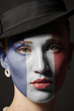 Woman face with painted France flag closeup