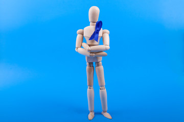 Blue awareness ribbon on a wood dummy figure 