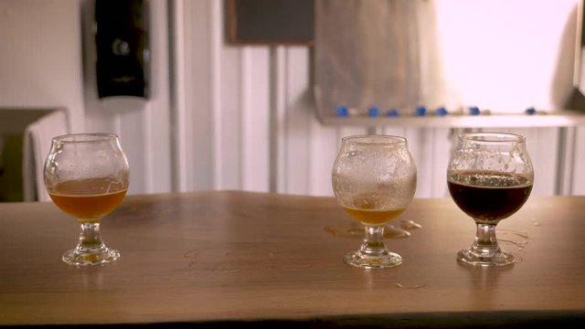 Hand reaches in to pickup a snifter of robust craft beer and puts it back