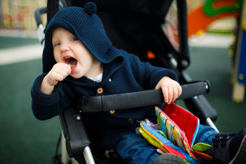 Obraz premium Little boy sitting in a baby carriage