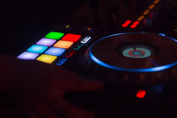 Closeup of DJ's hands mixing music . Night
