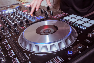 Obraz premium Professional concert dj turntables player device with sound mixer panel and jog wheel.Club disc jockey stage equipment for playing music on party.Digital turn table deck for nightclub