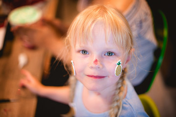 Girl make cake and muffin decorations. 
Close portrait of a girl with pigtails