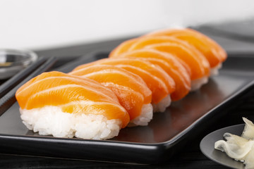 Sushi with salmon on a black plate. Ginger. Coricpace