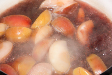 Boiling compote cooked in a pot of apples and black currant