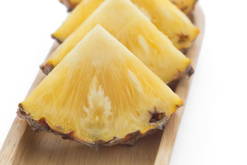 slice of pineapple on wooden plate.