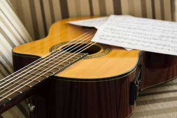Fototapeta premium music sheet on Acoustic guitar and both on the sofa