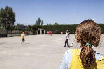 redhead girl watches as her classmates play