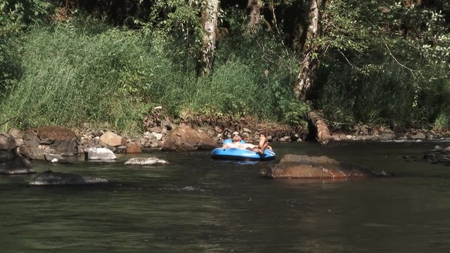 Model released man has a relaxing lazy day floating on raft in Washington river, enjoying the sunshine.