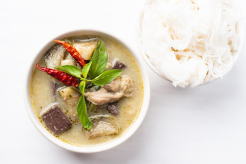 Green curry chicken (Kang Keaw Wan Gai) in a bowl and rice noodles, top view, Thai food