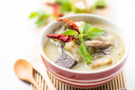 Green curry chicken (Kang Keaw Wan Gai) in a bowl with spoon and ingredients, Thai food