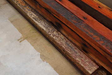 madeira maciça vermelha  cortada e estocada ao ar livre sobre cimento molhado sudeste do brasil 2018 