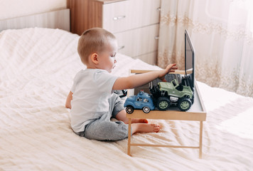 baby boy playing on computer or watching cartoons