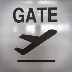 Picture of sign with an airplane taking off for the direction of the departure terminal at an airport