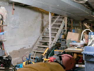 Concrete wall provides text space inside residential unfinished basement being used for storage,...