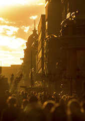 Crowd of people walking down the street at summer evening, beautiful light at sunset