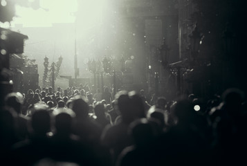 Black and white silhouette of people crowd walking down the pedestrian street under the sunshine